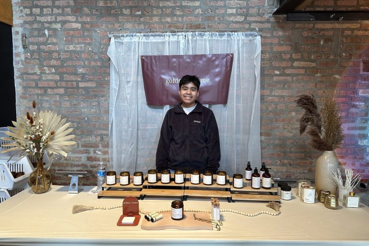 Daniel Pelaez standing behind his displayed candles and other products for Golden Home
