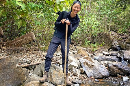 Chef Kristen Kish poses while crossing a stream in Panama's Chiriqui province.