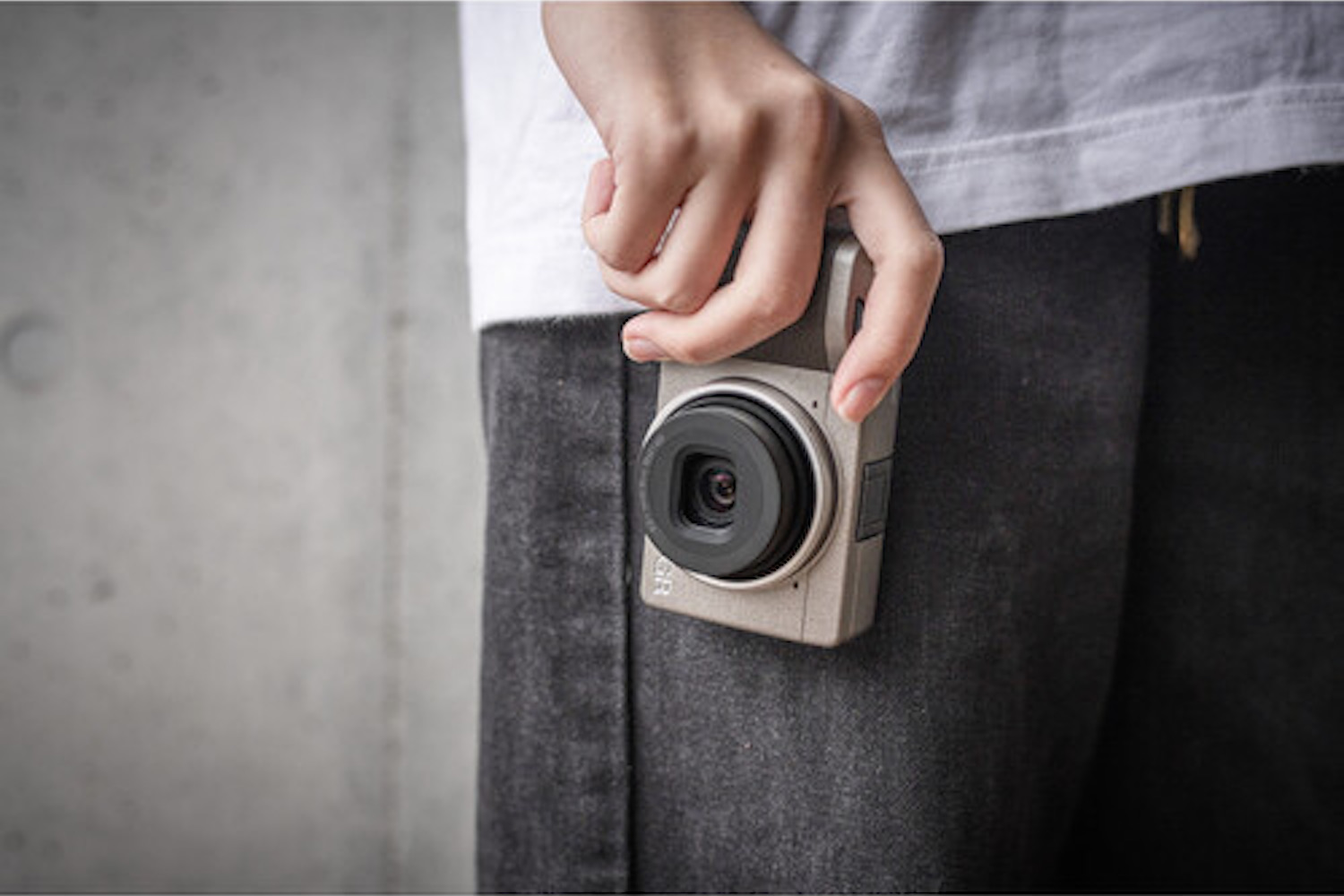 a model holding a Ricoh camera
