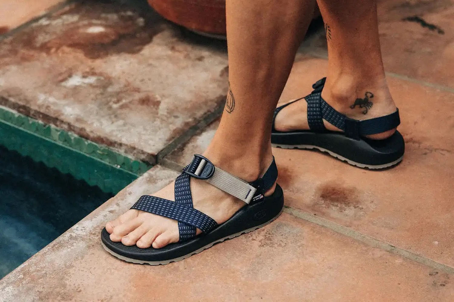 a model in a pair of Taylor Stitch x Chaco Z1 Classic by a pool