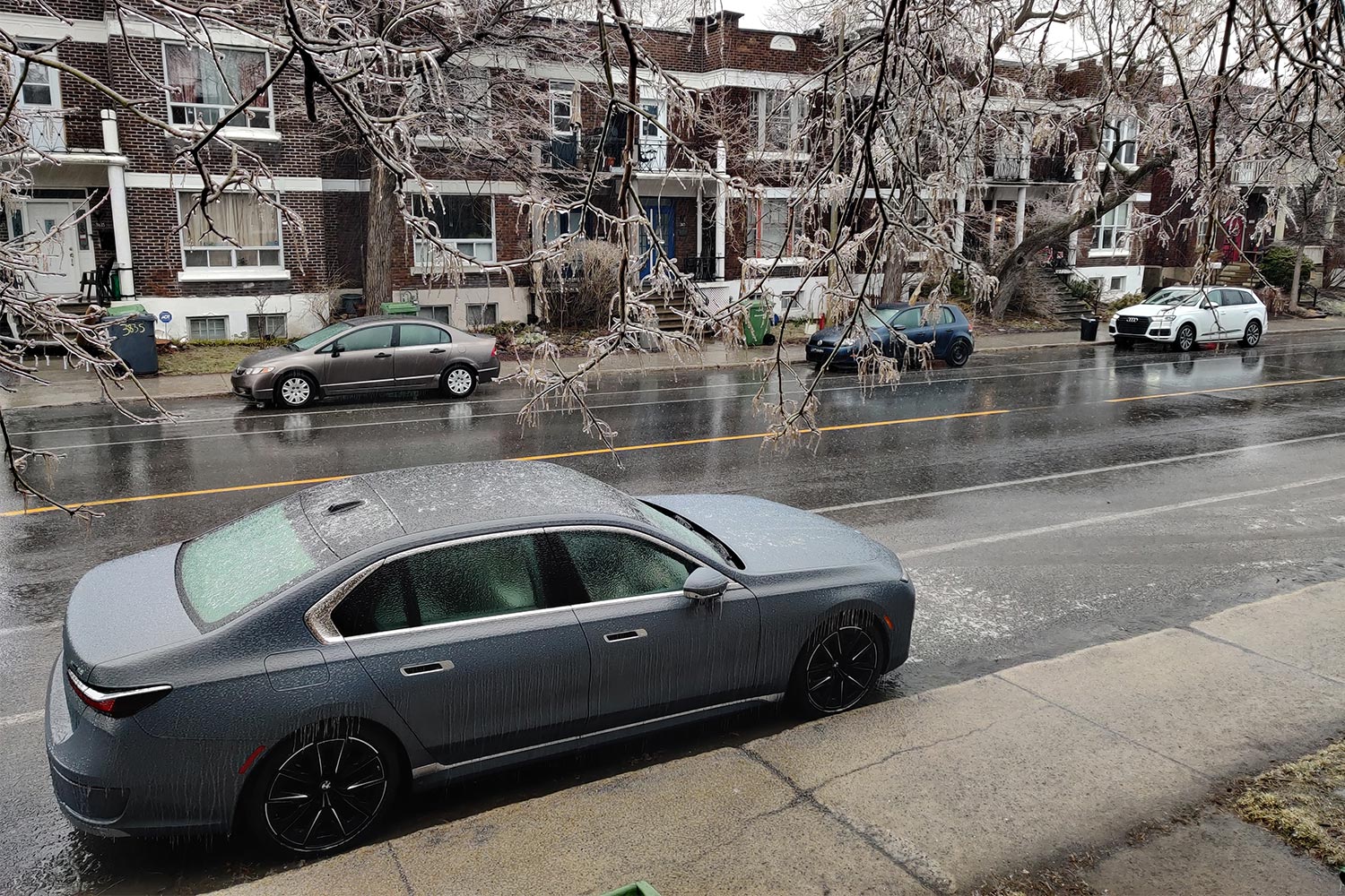 A BMW i7 electric sedan on an icy street during a winter storm