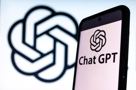 Photo illustration showing ChatGPT and OpenAI research laboratory logo and inscription at a mobile phone smartphone screen with a blurry background. The AI has been caught citing articles by The Guardian that don't exist.
