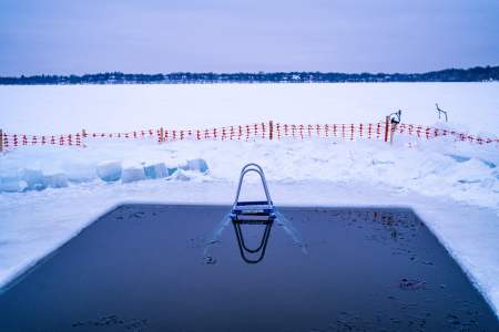 A cold plunge cut into the ice on a frozen lake in Minnesota