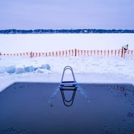 A cold plunge cut into the ice on a frozen lake in Minnesota