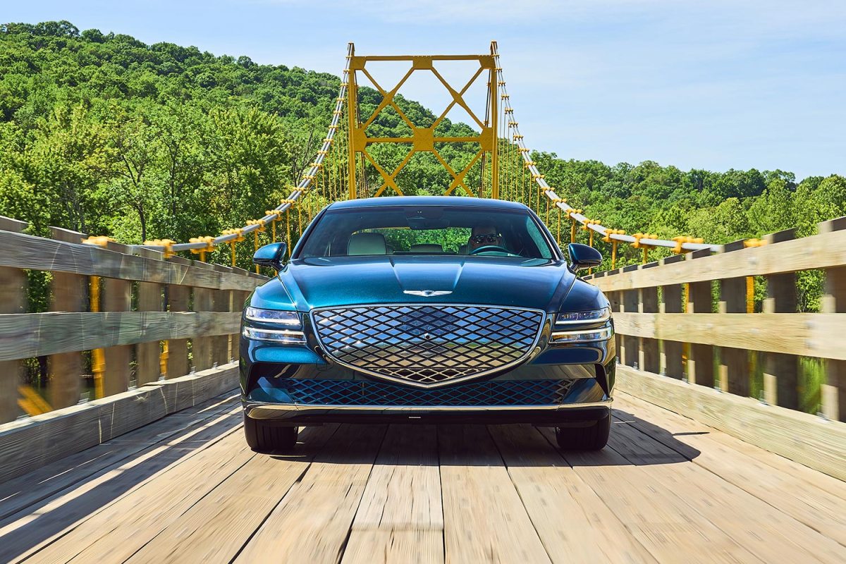 2023 Genesis Electrified G80 driving down a wooden bridge. We tested and reviewed the new EV sedan.