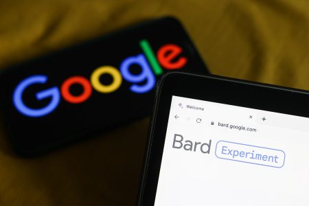 Google's new Bard AI chatbot website open on a laptop with the Google logo in the background