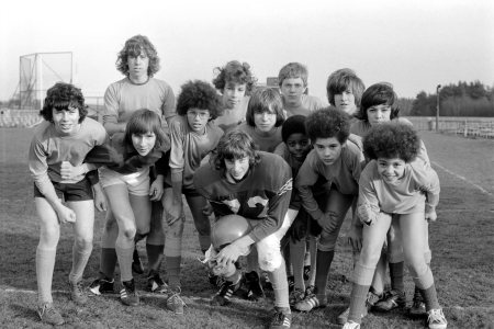A football team of teenagers depicted in a black and white photo