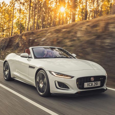 2023 Jaguar F-Type Convertible in white driving fast while the sun sets