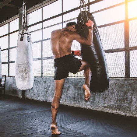 A Muay Thai fighter strikes a heavy bag with his knee.