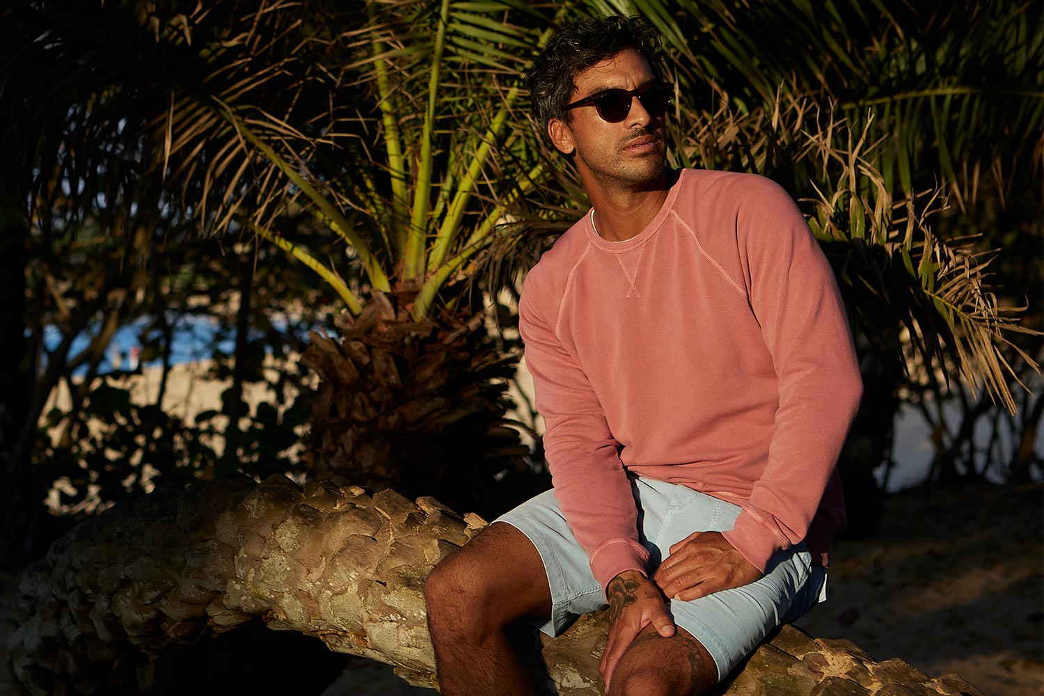 A man wearing a cotton sweatshirt and cotton shorts from the Outerknown California Series