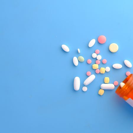 A bottle of pills spilling onto a counter. The FDA recently approved a second drug and the first pill made from human poop.