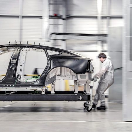 A worker moving an aluminum platform for a Polestar electric vehicle