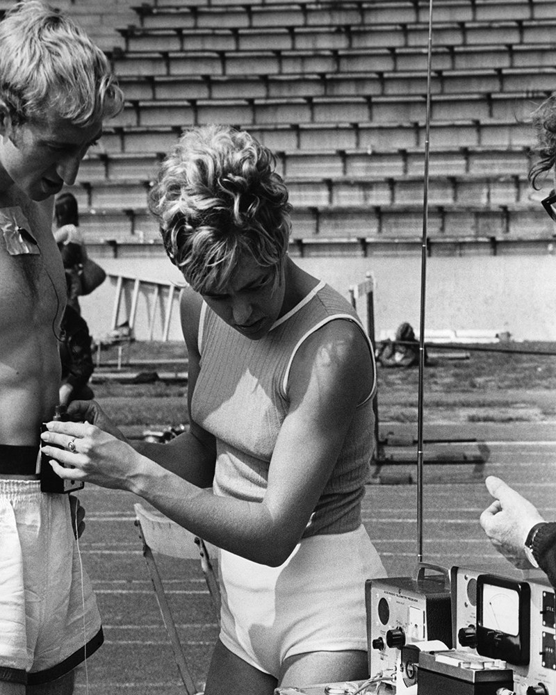 A woman preparing to measure an athlete's heart rate.