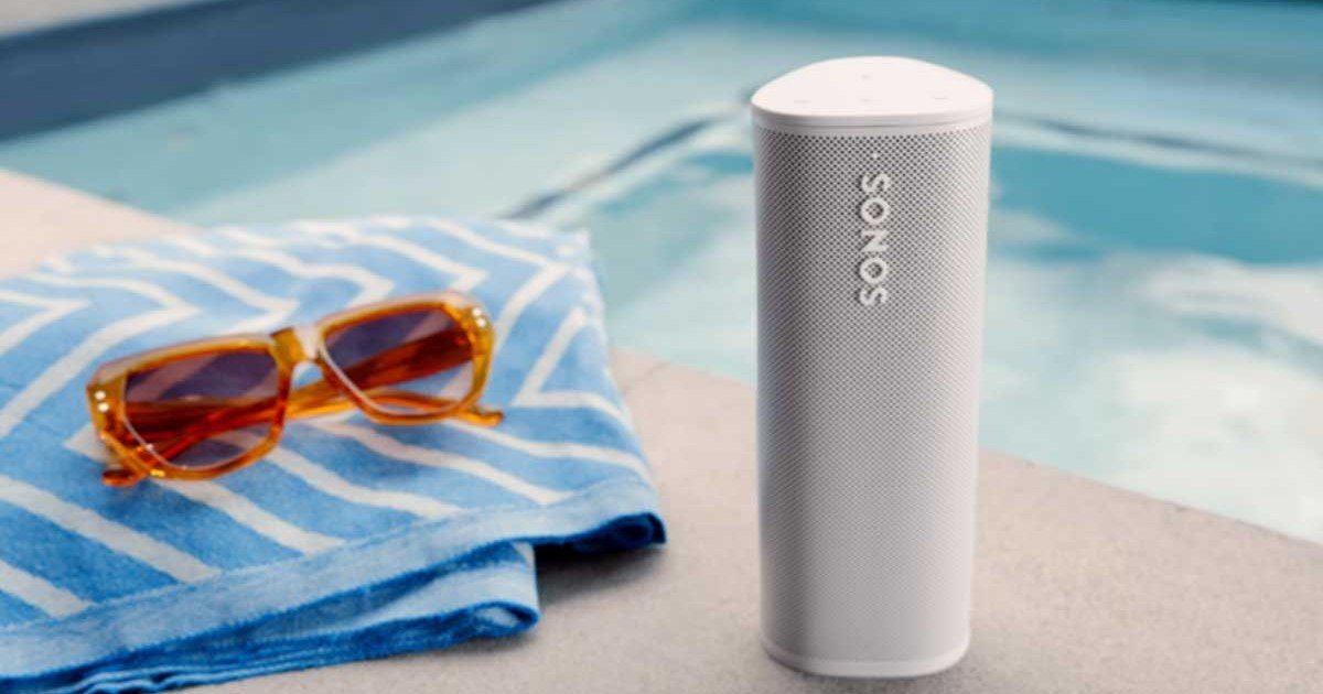 A Sonos Roam near a pool, towel and sunglasses. Sonos gear that is refurbished often nets you an extra discount.