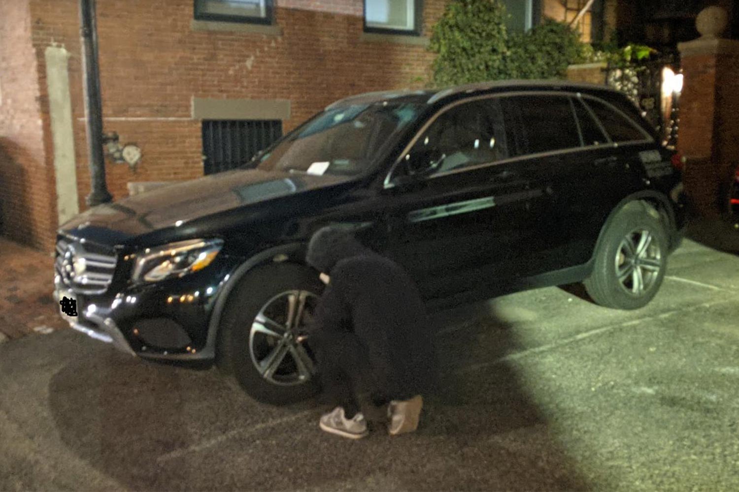 A photo of a person in black deflating the tires on an SUV in Boston, courtesy of Tyre Extinguishers on Twitter (@T_Extinguishers)