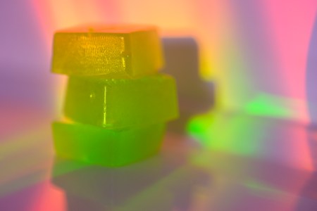 A stack of edible cannabis gummies in rainbow light