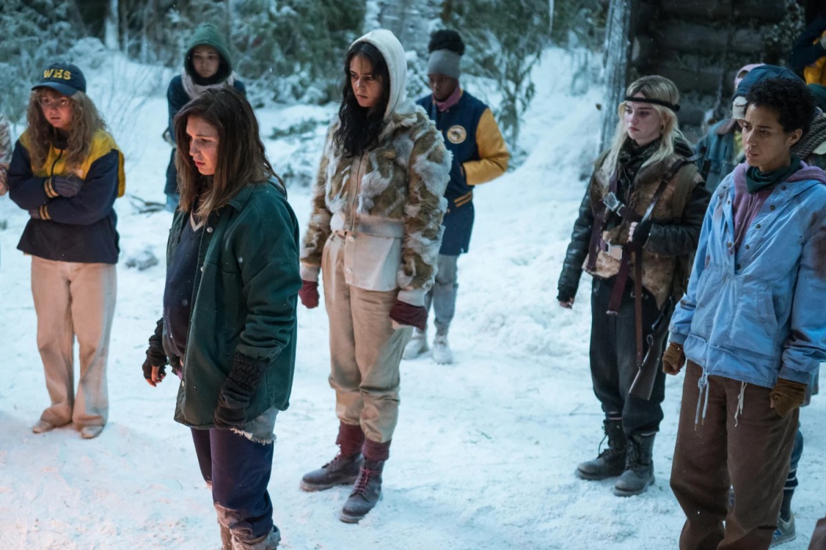 The stranded girls from "Yellowjackets" collect outside the cabin during the snowy months