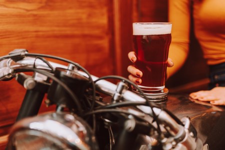 Young woman holding beer on a motorcycle