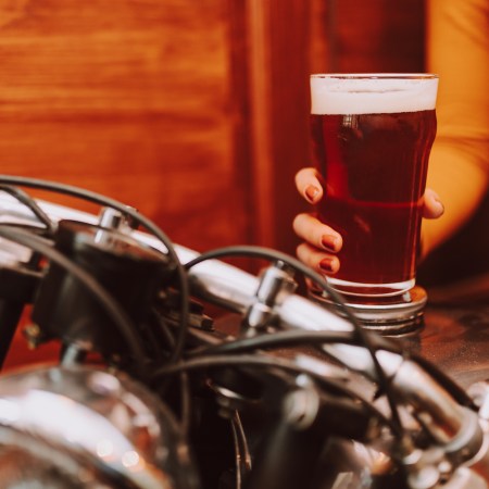 Young woman holding beer on a motorcycle
