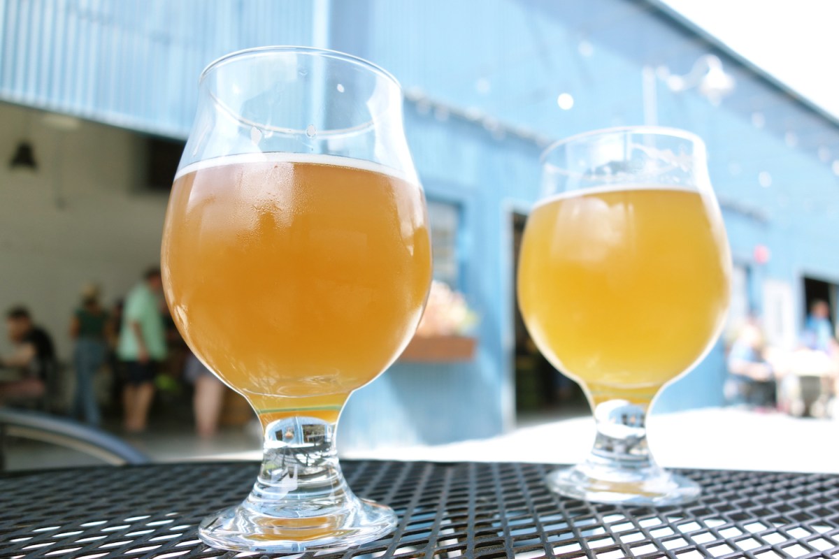 two wheat beer pints at a microbrewery in an outdoor courtyard table