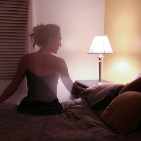 Silhouette of woman sitting on bed