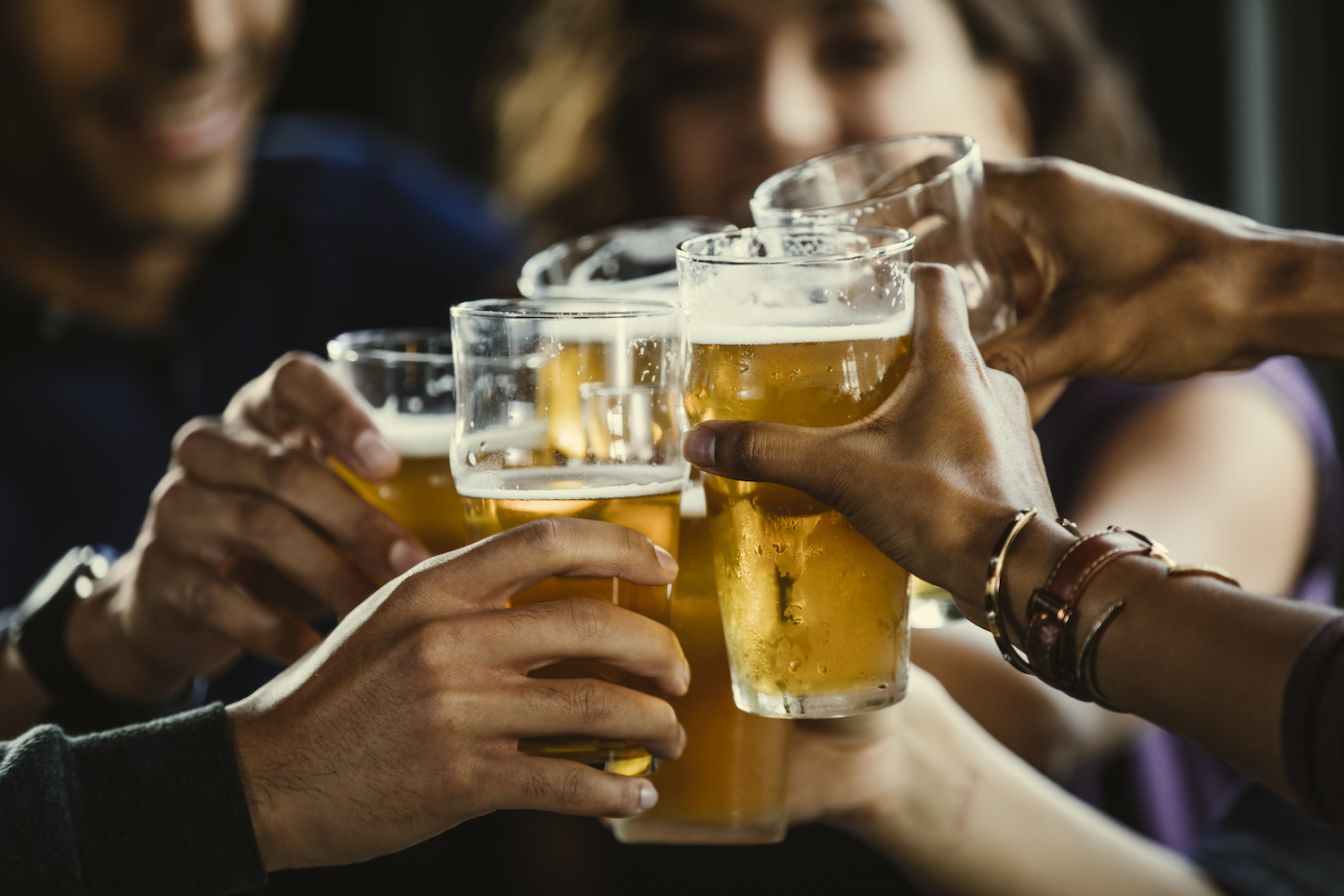 Group of friends toasting beer glasses