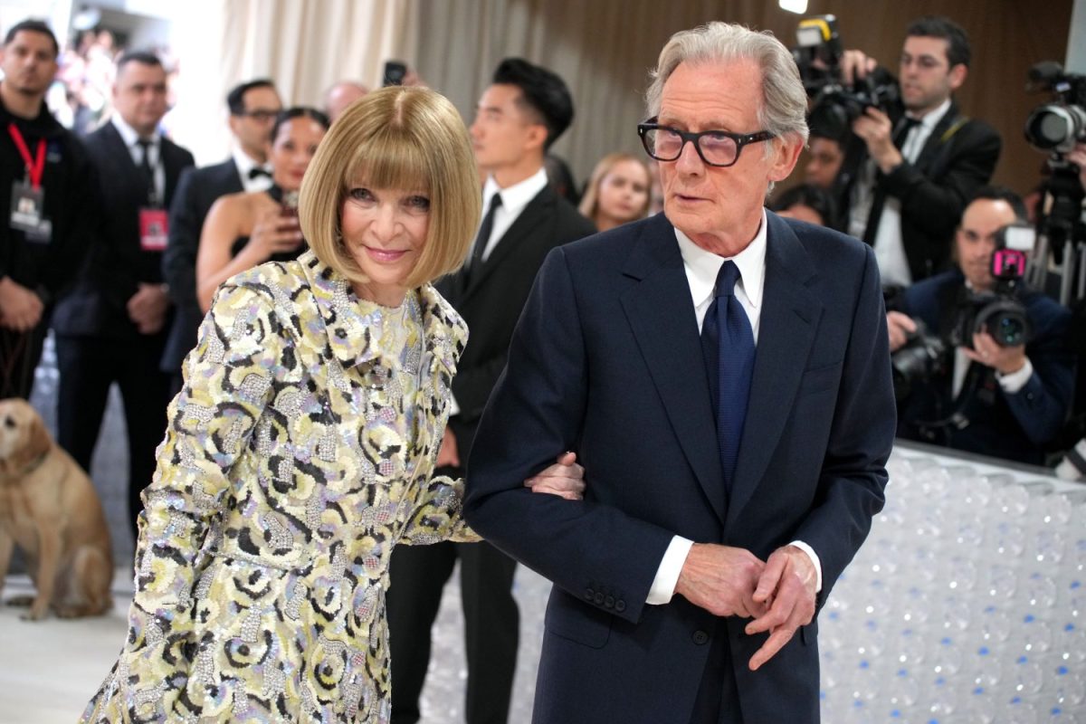 Anna Wintour holds Bill Nighy's arm while they walk together at the 2023 Met Gala.