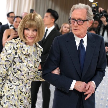 Anna Wintour holds Bill Nighy's arm while they walk together at the 2023 Met Gala.