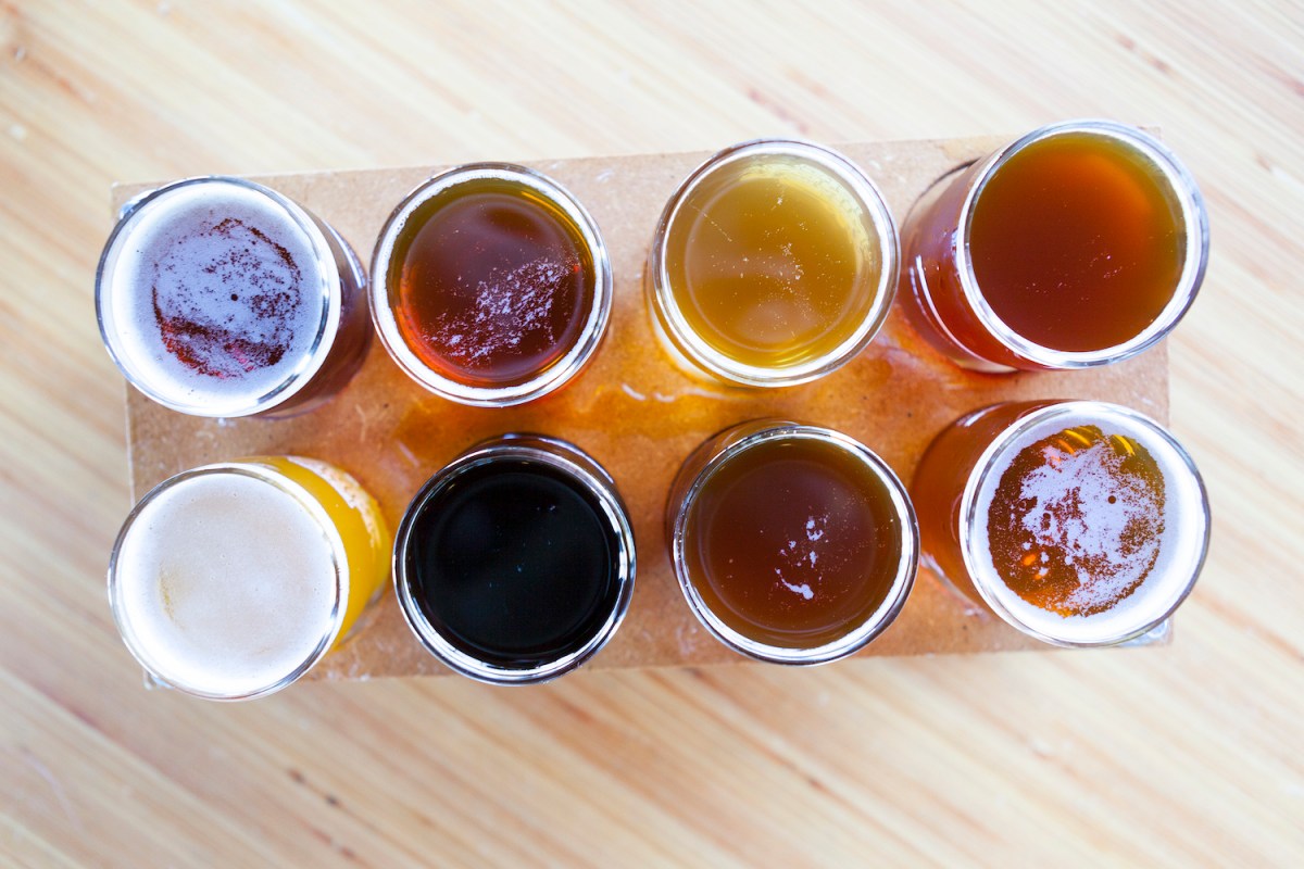 flight of 8 beers on a wooden board
