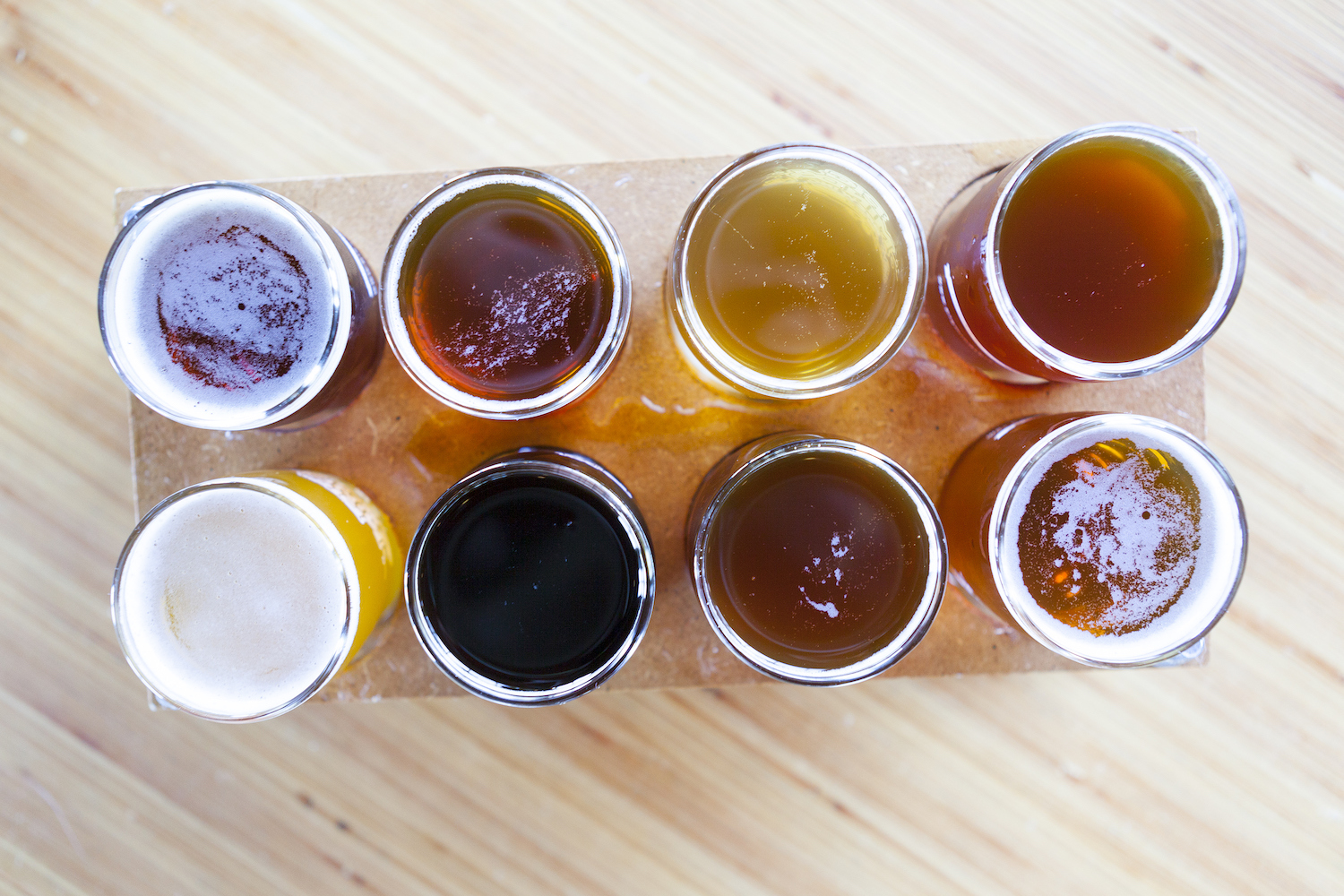 flight of 8 beers on a wooden board