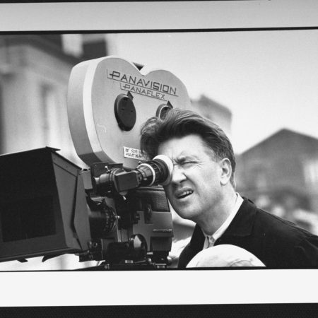 David Lynch looking into a film camera. Today, Daniel Knox ranks all of Lynch's films.