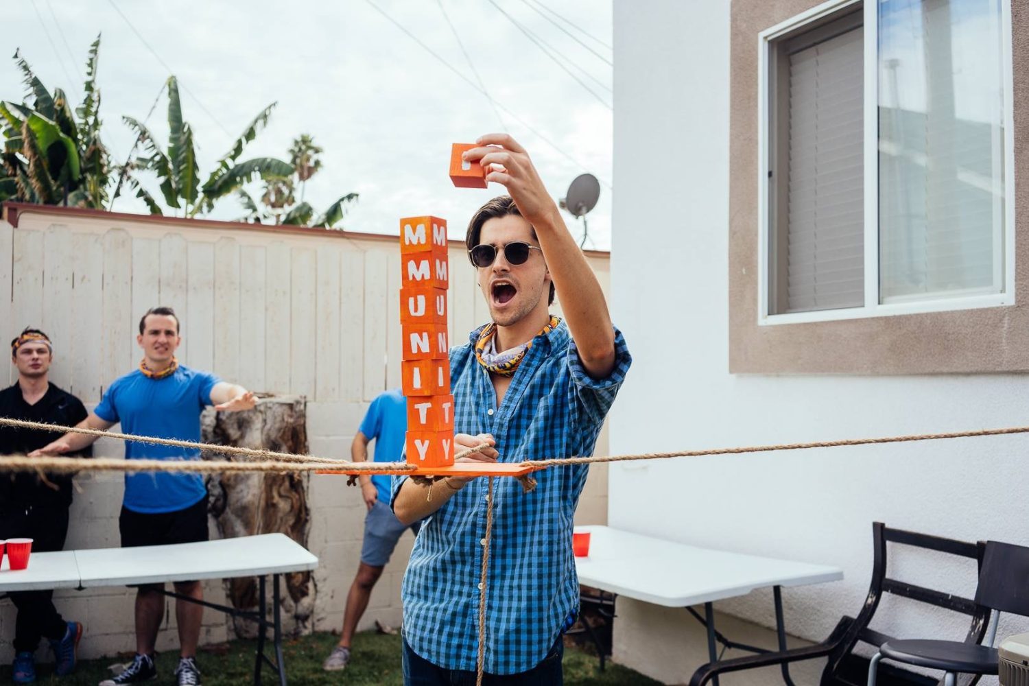 A guy balancing blocks on a wooden strip in the air.