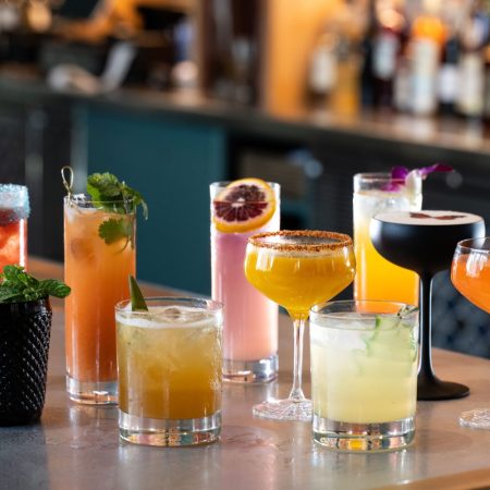 A spread of cocktails on a bar table.