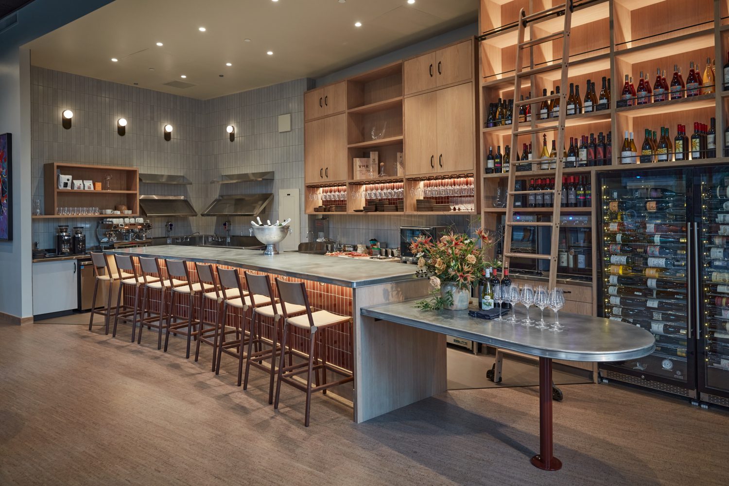 A wide shot of a bar with wine bottles behind it. SF best new restaurants