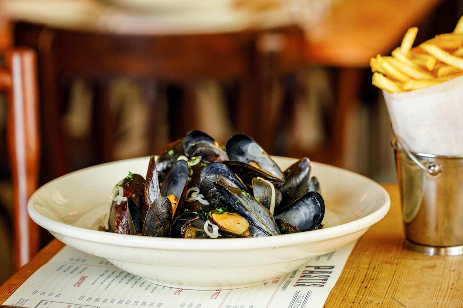 mussels in a bowl with a side of fries