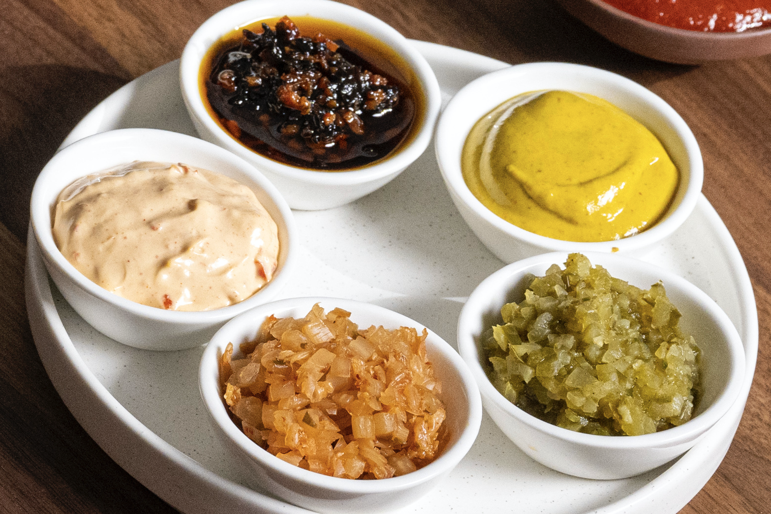 The five condiments that come with Mischa's hot dog.