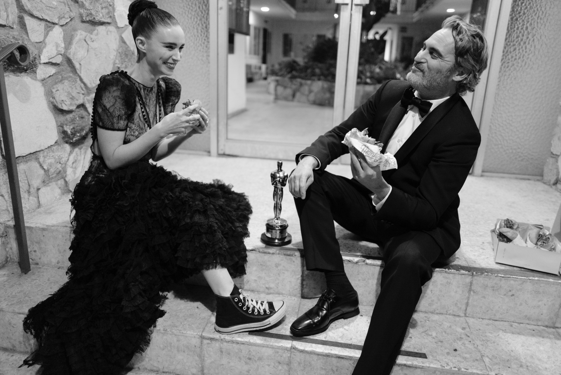 "This picture of Joaquin Phoenix and Rooney Mara was taken on Oscar night, just after Joaquin had won Best Actor for <em>Joker</em>. The story in this picture, for me, is a love story. You have two people that clearly adore each other and who, despite their great fame, are really quite down-to-earth and at their happiest in each other’s company. There’s an authentic cuteness to Rooney’s Converse trainers. She’s taken off her high heels and she’s got her ball gown on still, but she’s wearing Converse. And there they are just chomping down on these vegan burgers. The idea behind this image was that Joaquin and Rooney wanted to use Joaquin’s Oscar win and the attention that it brought to highlight veganism, a cause very close to both of their<br>hearts."<br>