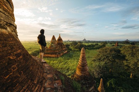 tourist standing on beautiful pagoda during a stunning sunrise in Bagan, Myanmar