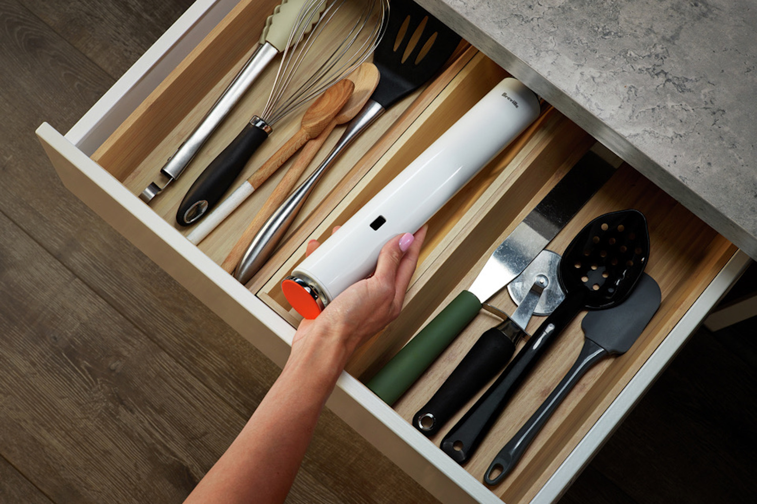 a model holding the Breville Sous Vide over an open kitchen drawer