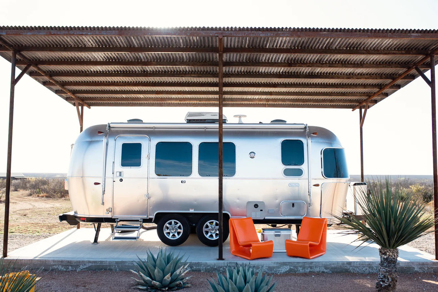 a pair of tupelo chairs in front of an airstream