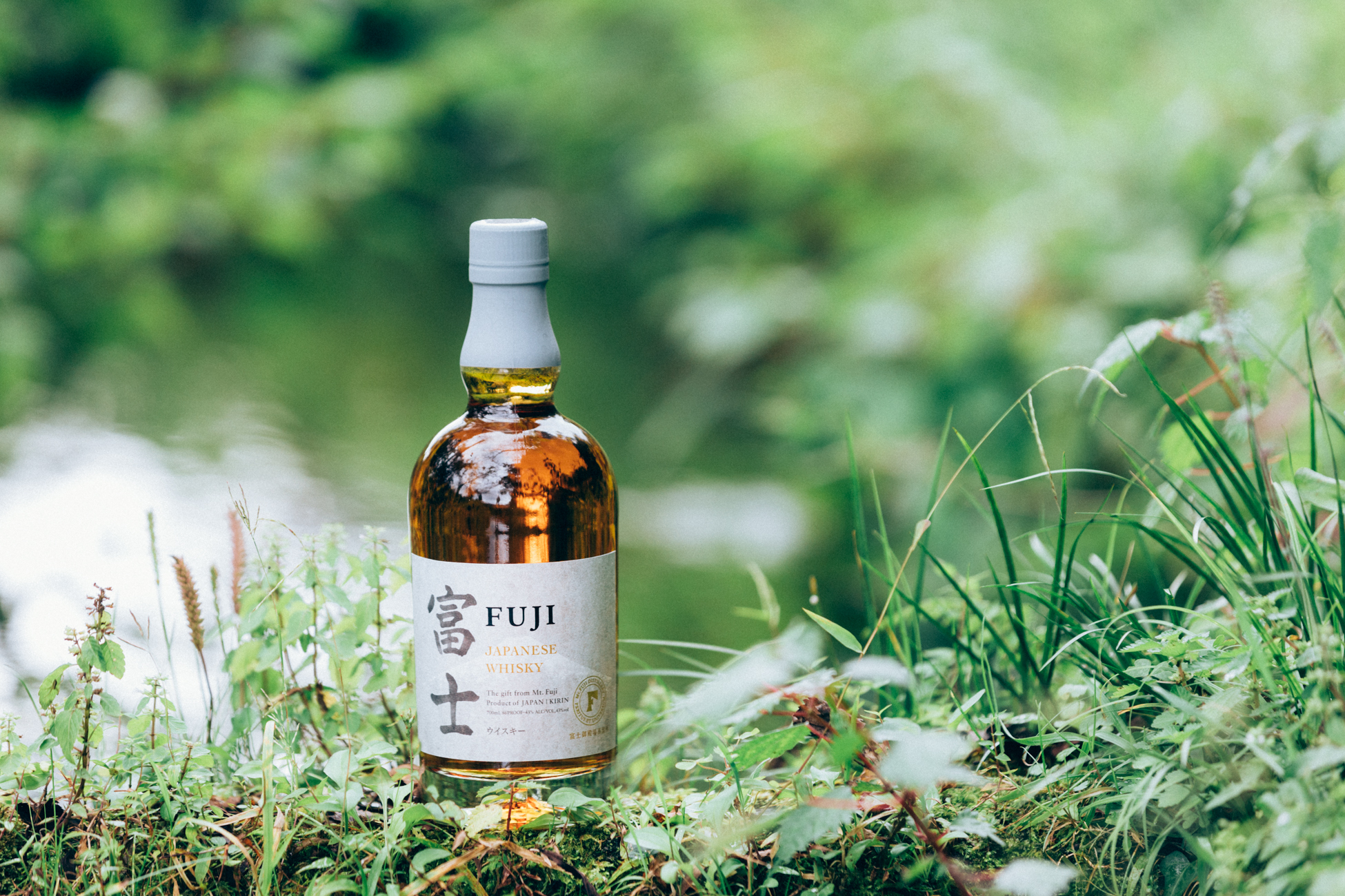 a bottle of FUJI Japanese Whiskey in a grassy field