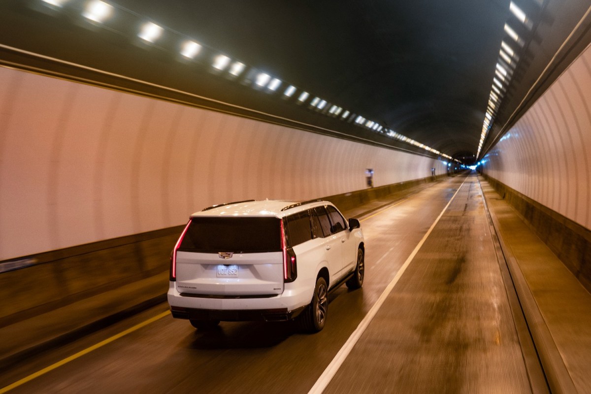 The Cadillac Escalade driving through a tunnel. GM announced the electric Cadillac Escalade IQ will be unveiled in 2023.