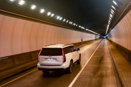 The Cadillac Escalade driving through a tunnel. GM announced the electric Cadillac Escalade IQ will be unveiled in 2023.