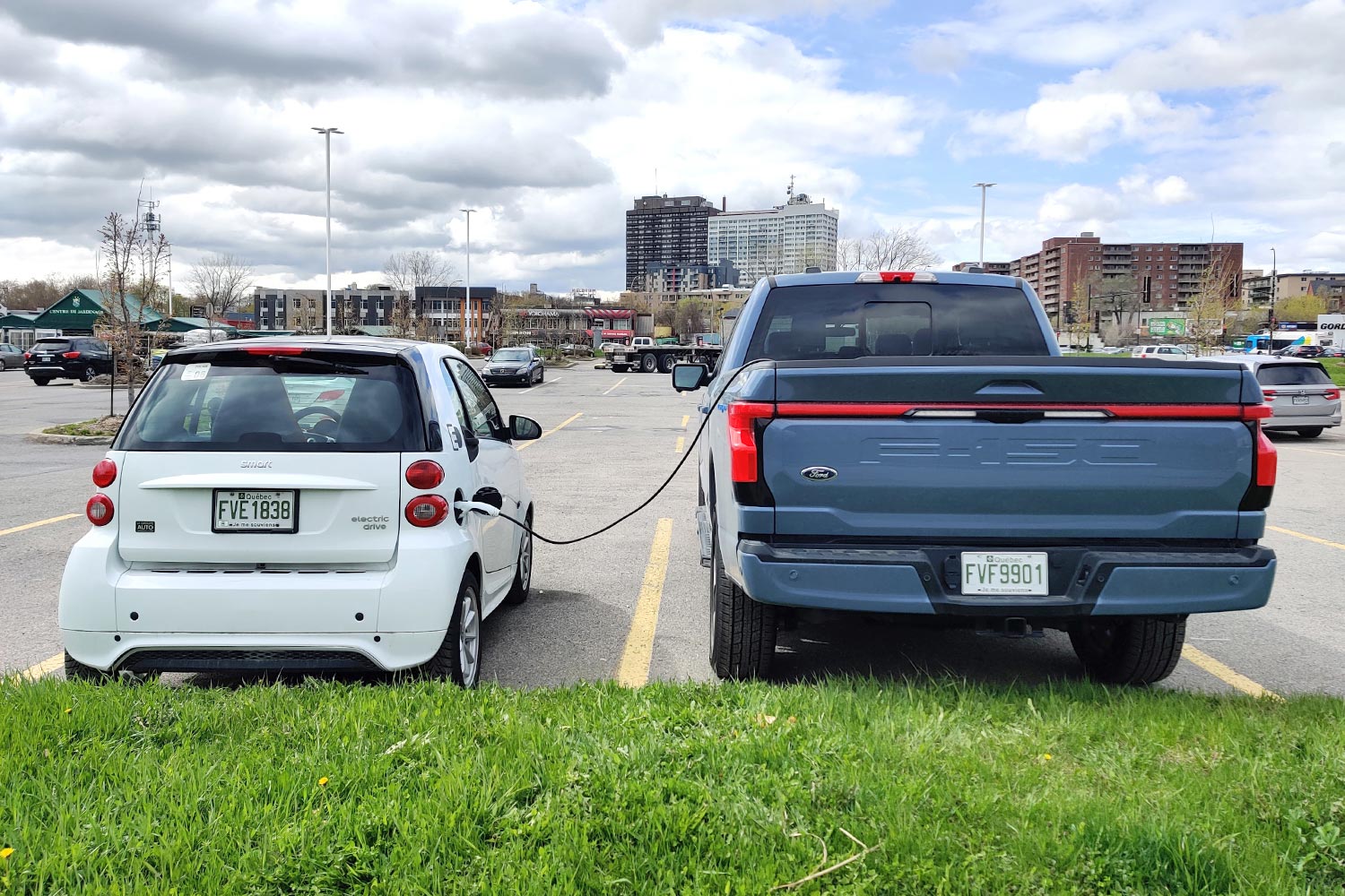 Vehicle-to-vehicle charging, as seen in a Ford F-150 Lightning charging a Smart Fortwo Electric Drive