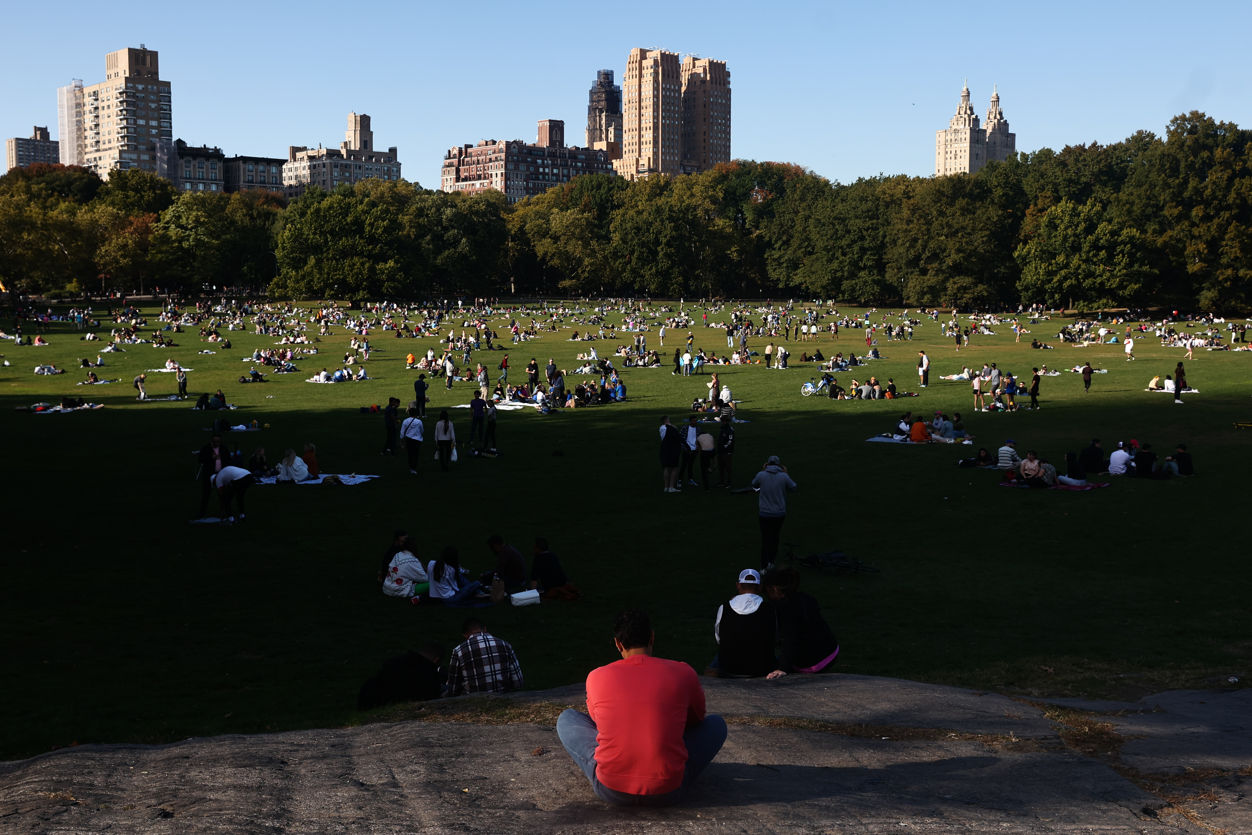 People rest on the Sheep Meadow in the Central Park in New York City, United States on October 22, 2022. (Photo by Jakub Porzycki/NurPhoto via Getty Images)