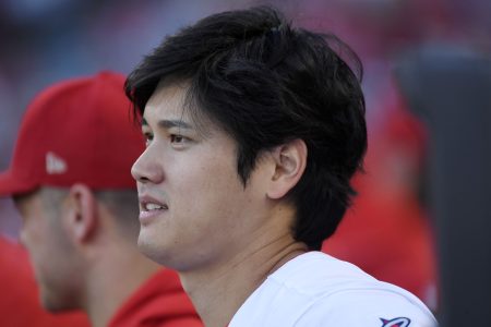 Shohei Ohtani looks at a game from the dugout.