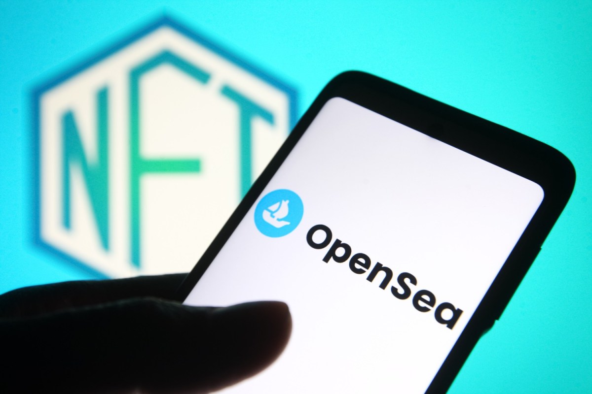 OpenSea logo on a smartphone, with the word NFT in the background