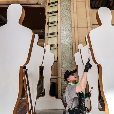 Saule Pictys touches up Oscar cutouts as crews continue to build the red carpet at the 94th Academy Awards at the Dolby Theater.