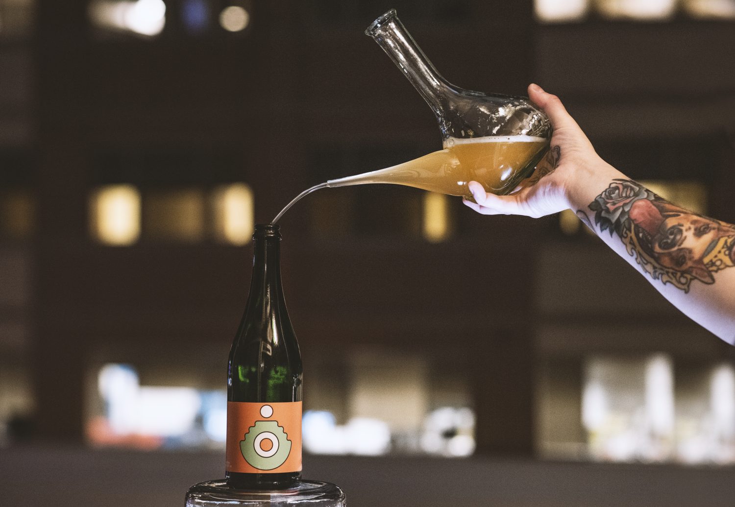 A mixed-fermentation beer from Crooked Run being poured from a glass vessel into a bottle