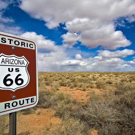 Route 66 sign in front of desert and blue sky